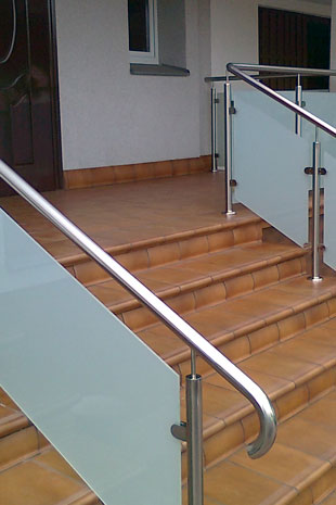 Treppengeländer im Eingangsbereich montiert von oben auf der Natursteintreppe, mit Einlagen aus Milchglas VSG aus ESG, Pfosten und Handlauf in Rudnrohr 42,2mm, Glasklemmhaltern Zertifiziert nach DIN
