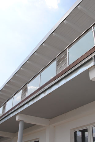 Brüstungsgeländer in Edelstahl matt Korn240 montiert von oben auf den Balkonen, Milchglasfüllung