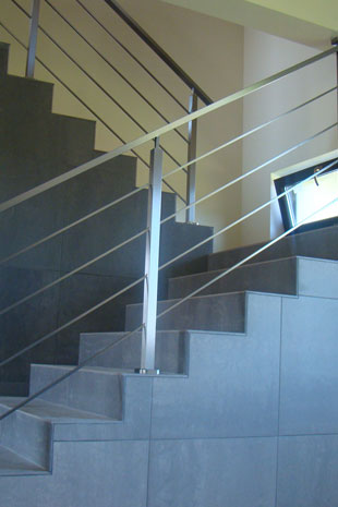 Treppengeländer mit paralleler Füllung in Rundmaterial fi12 und quadratischen Pfosten der Handlauf ist in einem Rechteckprofil ausgebildet 20x40mm, das Geländer ist von der Oberflächenbehandlung matt ausgeprägt